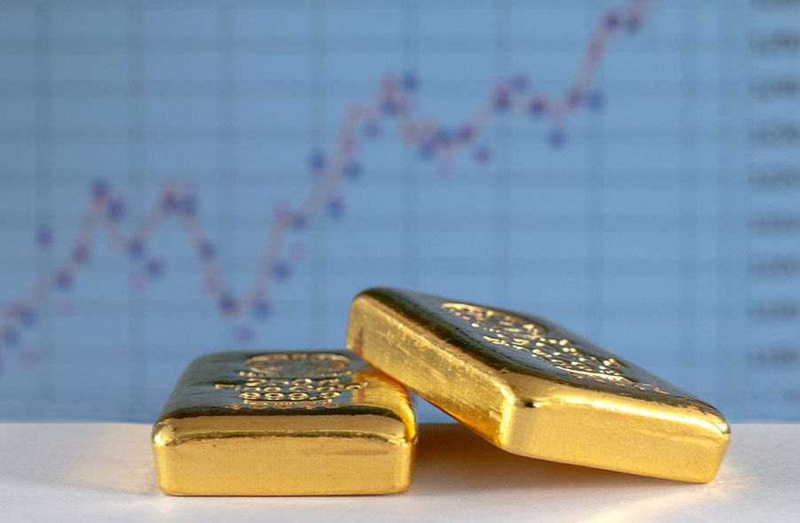 gold bars with stock charts on the background