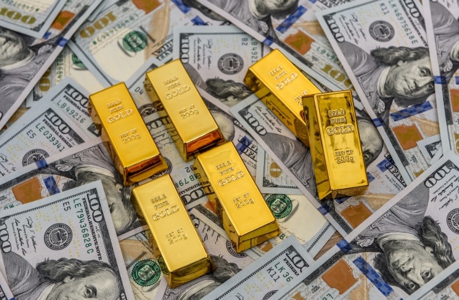 золотой слиток поверх долларов США