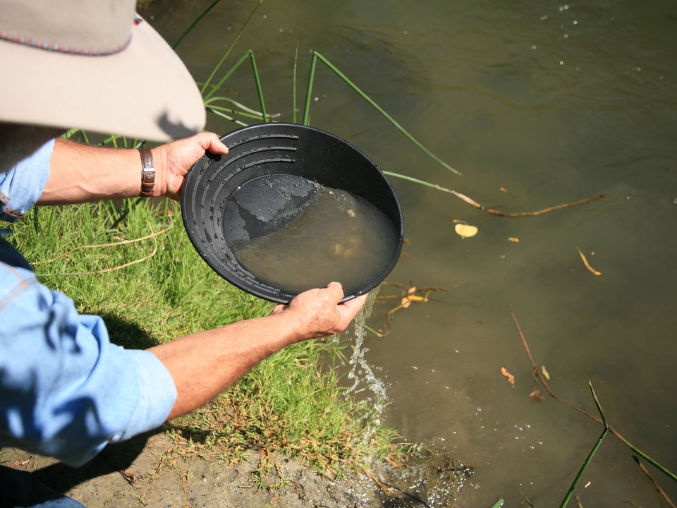 man gold panning in a river