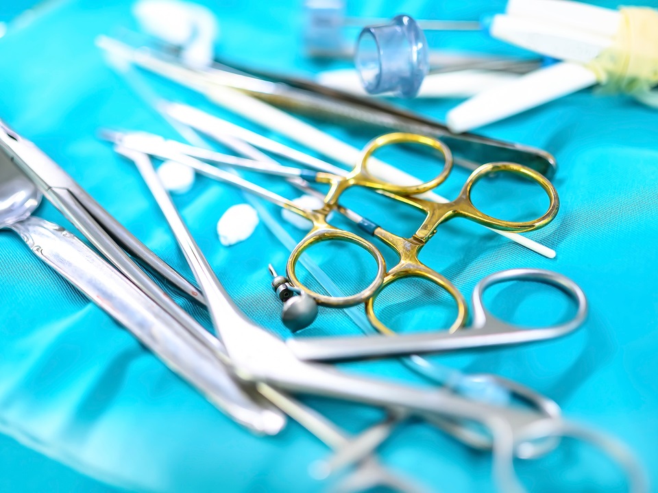 gold plated surgical scissors beside other instruments