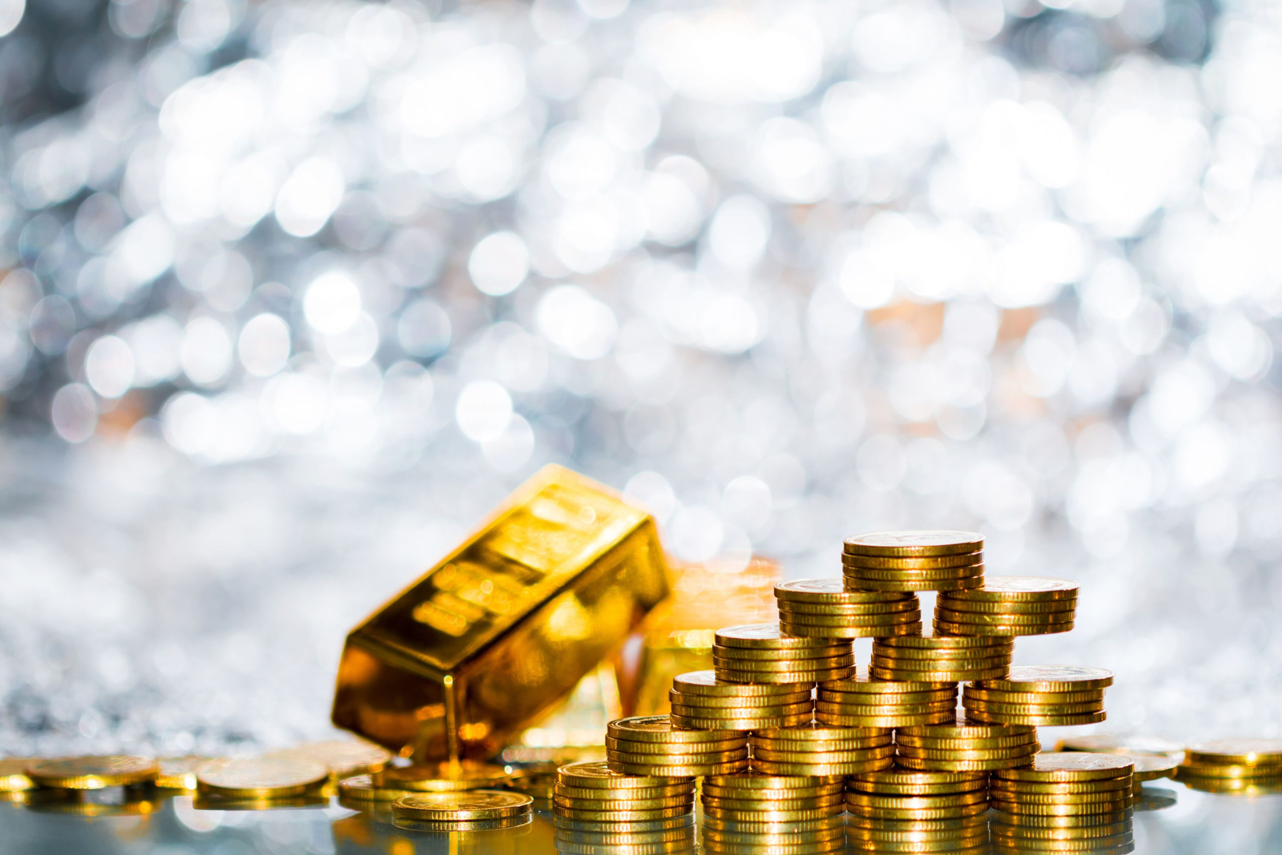 stack of gold coins and gold bars with bright background