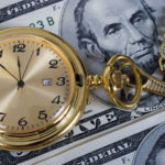 retirement gold watch on five dollar bill background