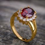 24 karat gold ring with red and white gemstone