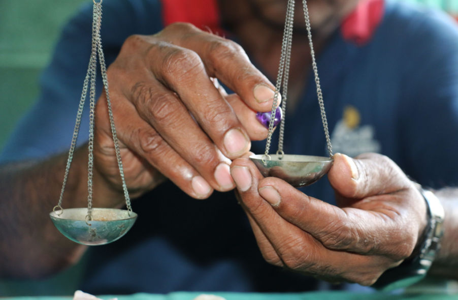 trader using old method of weighing gemstone