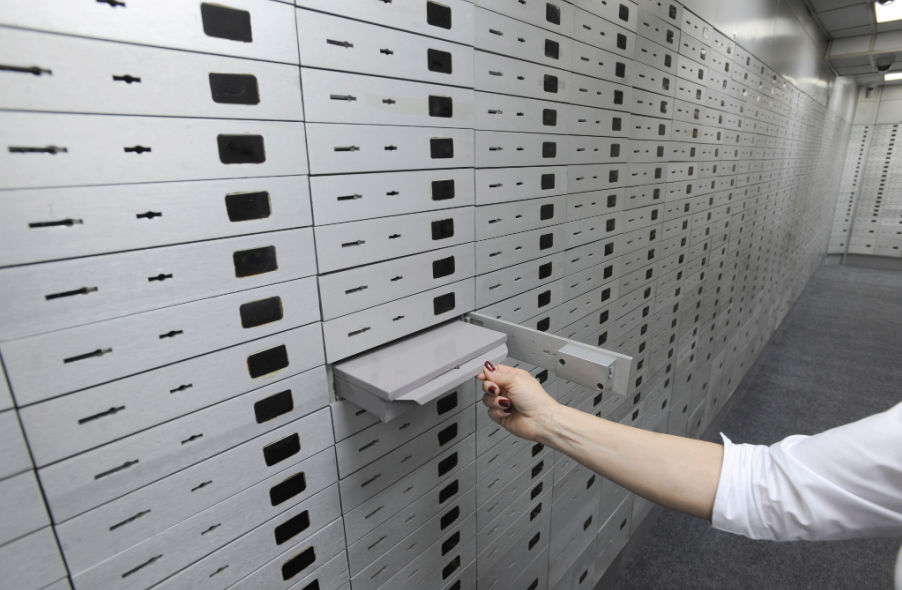 banker opens safe deposit box cell in bank treasury
