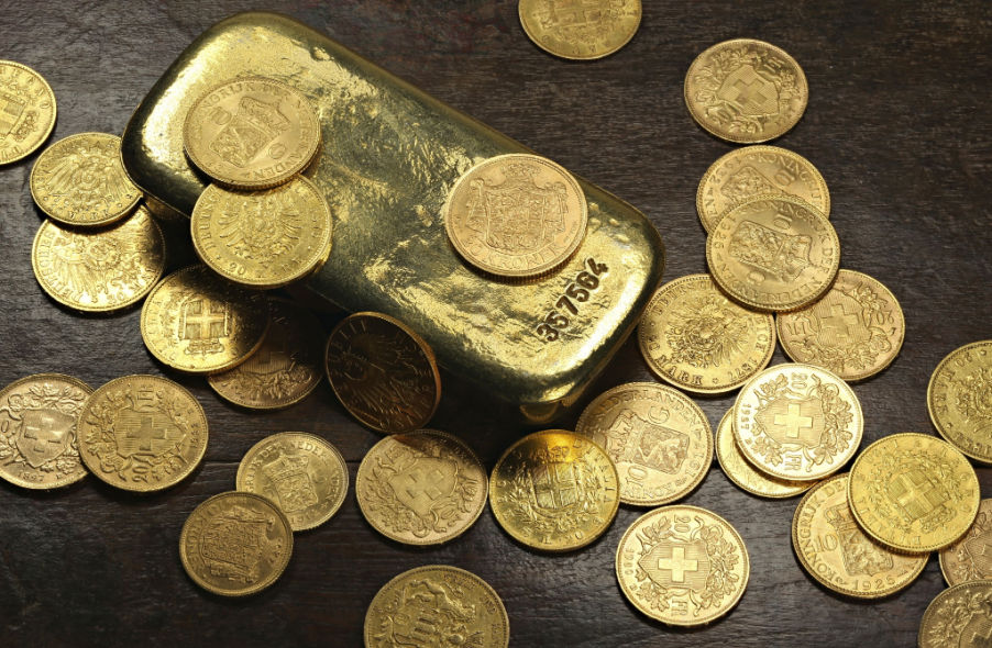 gold coins and gold bar on wooden background