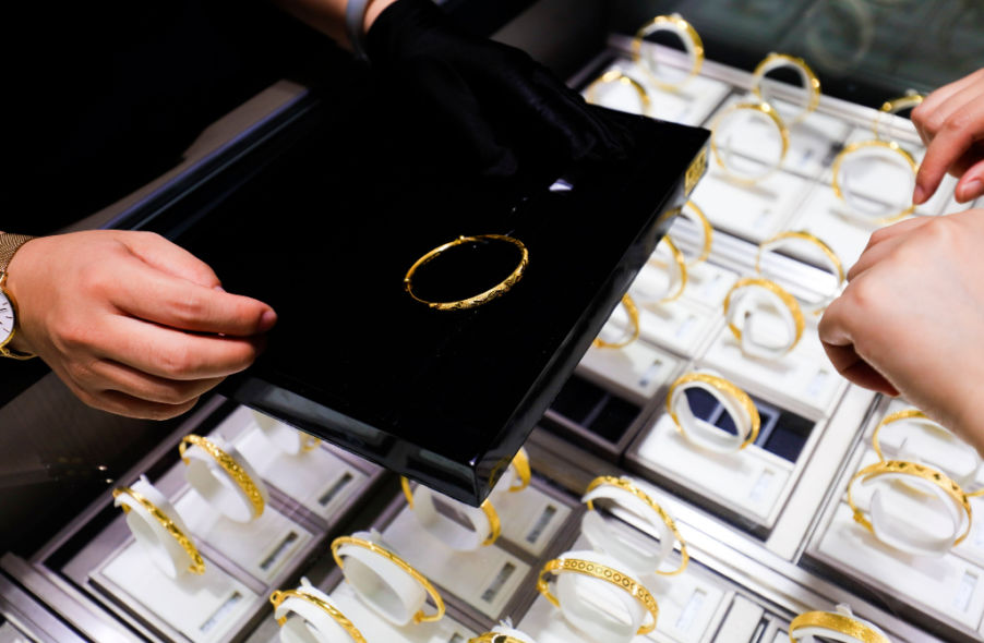 woman buying gold bracelet in jewelry shop