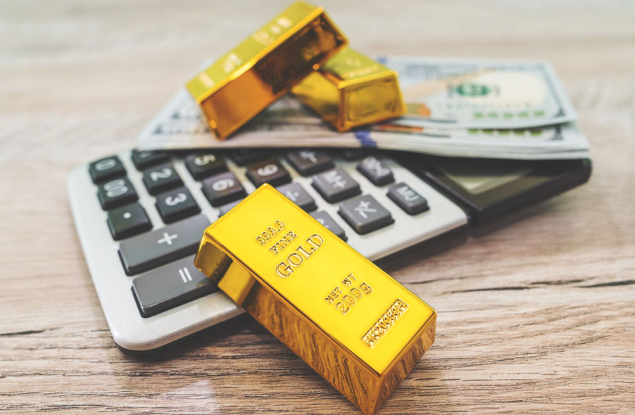 gold bars with calculator and dollar banknotes