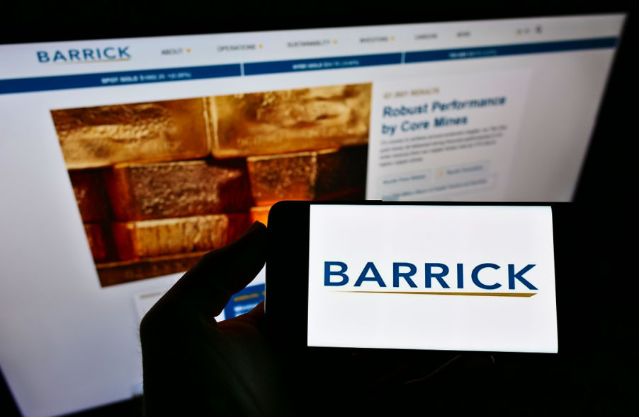 person holding smartphone with barrick gold corp logo on barrick gold corp website