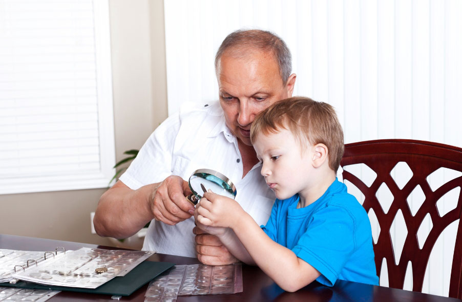 grandfather-and-child-looking-at-coin-collection