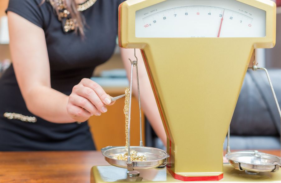 female jeweler weighing gold jewelry to check the price