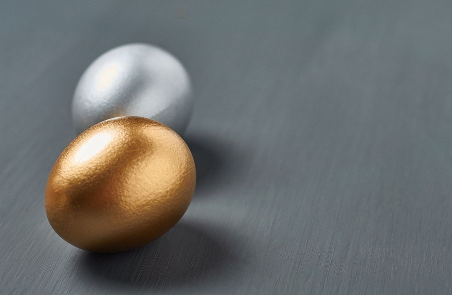 silver and gold egg on dark concrete background