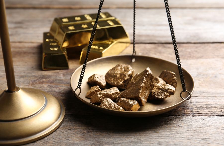 gold bar and scale pan with gold lumps