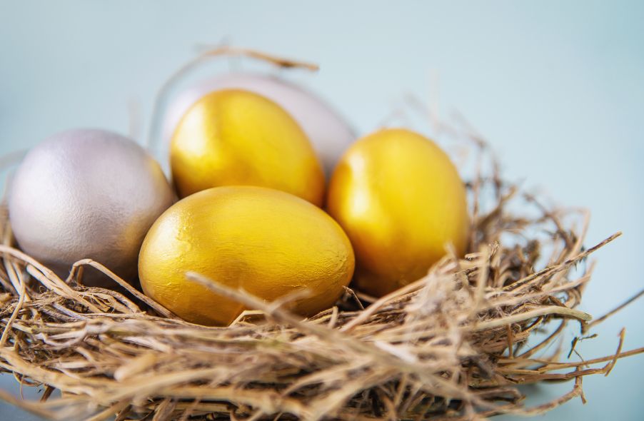 three gold eggs and two silver eggs on nest