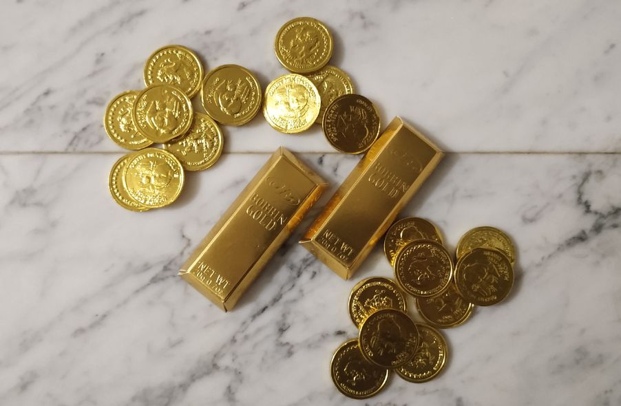 gold coins and gold bars on marble background