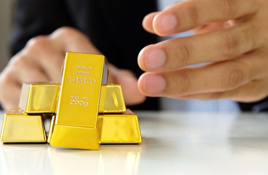 businessman stacking two hundred grams gold bars