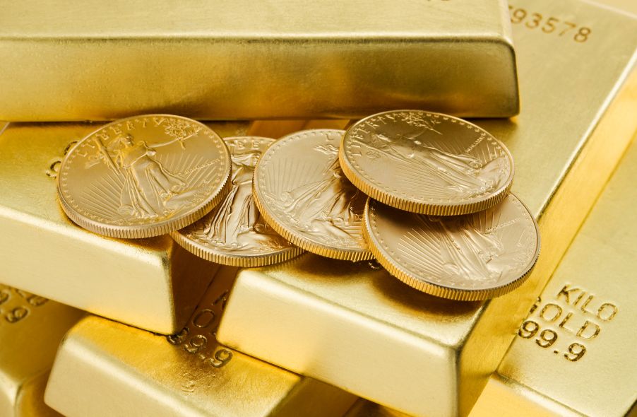 five gold coins on top of gold bars