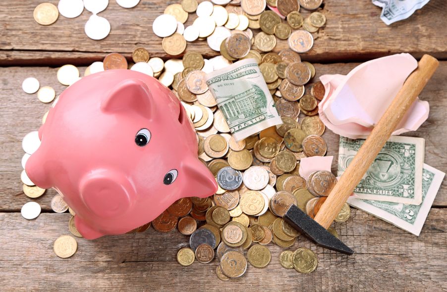 broken piggy bank with coins and bills